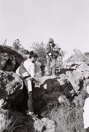 Photograph of two people looking at a rock outcrop.