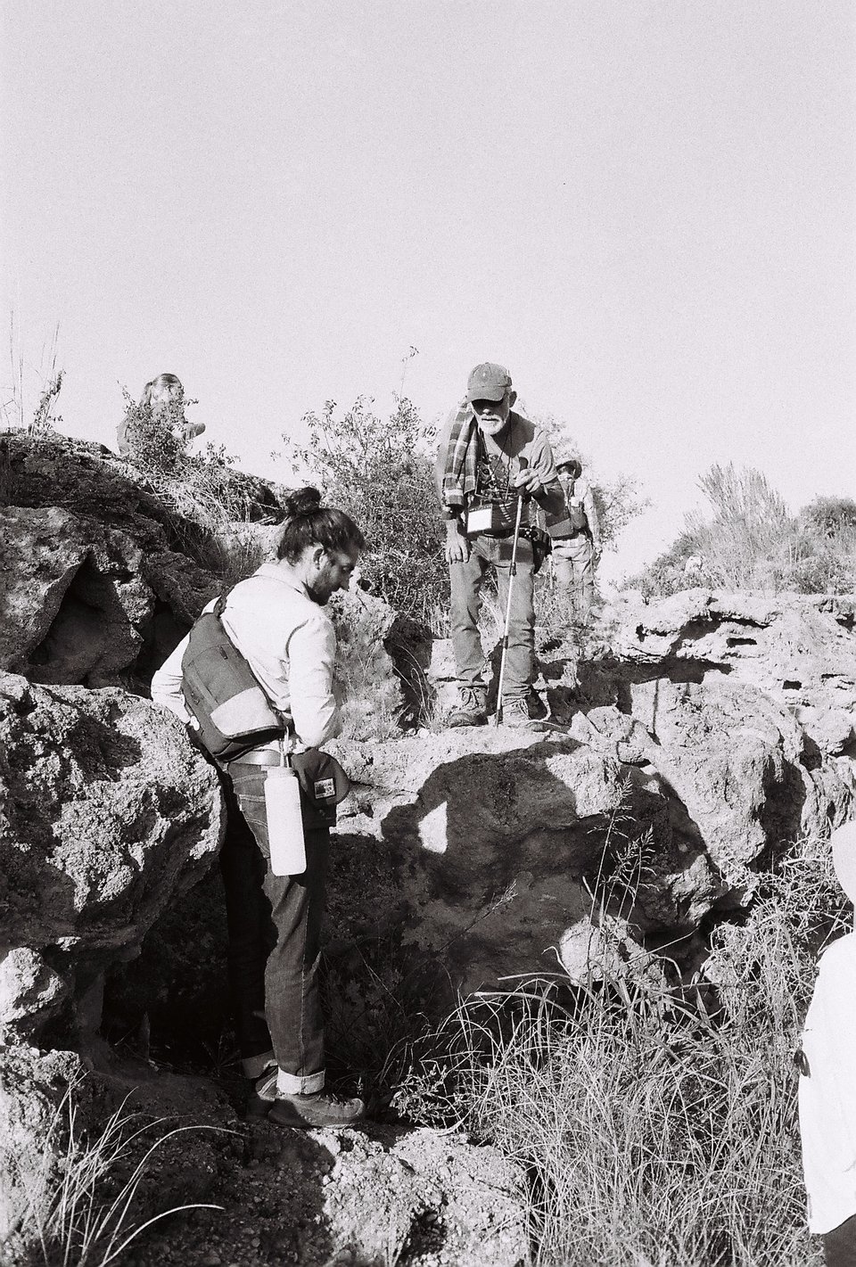 Photograph of two people looking at a rock outcrop.